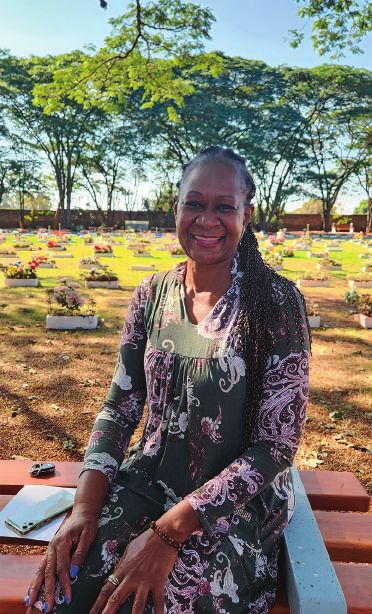 Aida sentada em um banco no Lírios Cemitério Parque