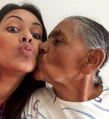 Dona Antônia beijando o rosto da filha caçula, Karina