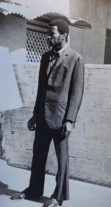 Retrato de Xavier Pedro Matine de terno, em frente a um muro